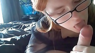 Pretty teen lass with glasses giving blowjob